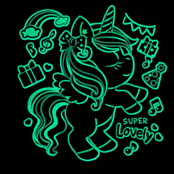 image of the pajama shirt glowing in the dark. outline of unicorn and party decorations 