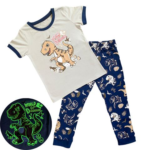 glow in the dark t-rex pajamas. light brown shirt with t-rex that glows in the dark with World of Dinosaurs and dark blue t-rex pajama pants. snug fit